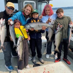 Smiling Family Holding Freshly Caught Fish On A Family-friendly Fishing Charter In Puget Sound, Seattle.