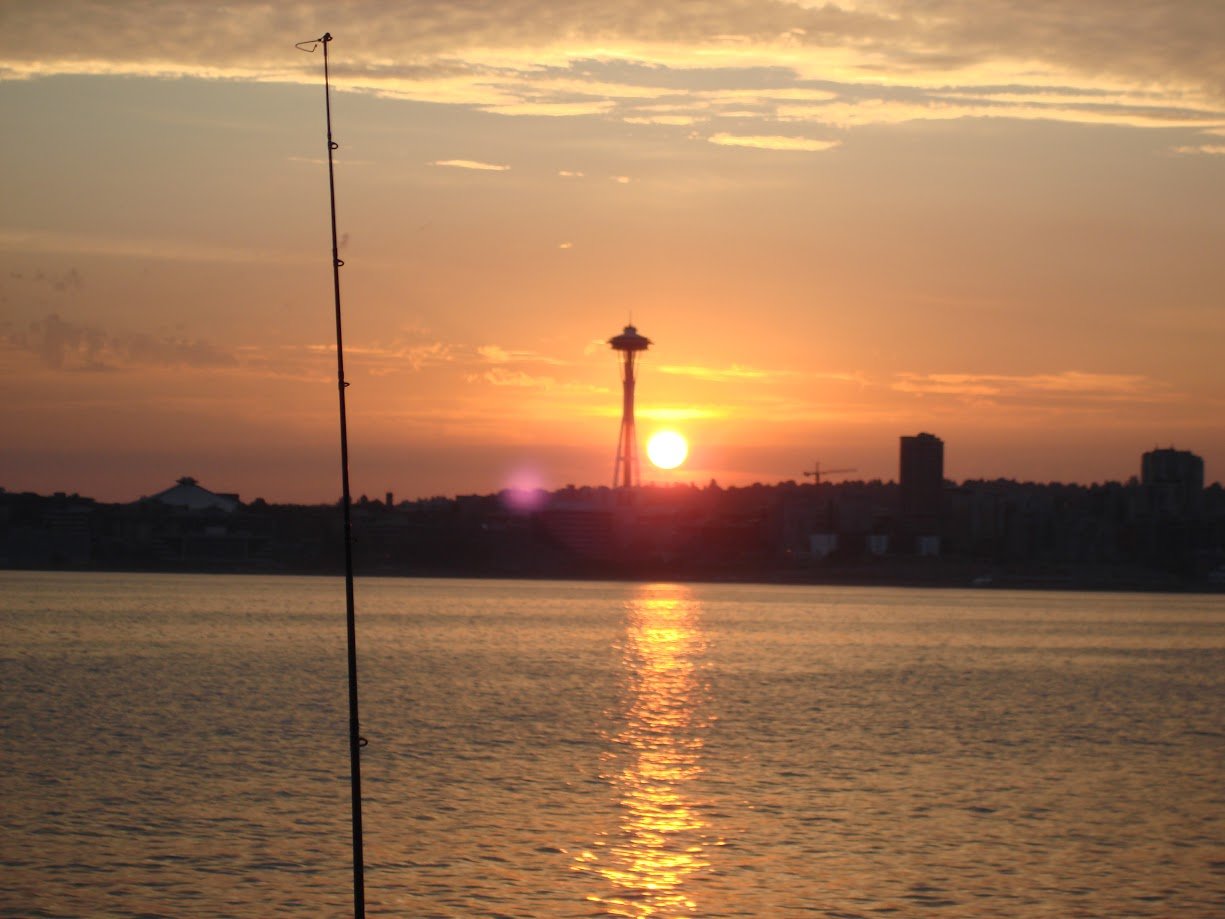 Fishing Rod At Sunrise In Puget Sound With Seattle Skyline And Space Needle, Perfect For Fishing Tours And Outdoor Adventures In Seattle.